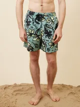 Short de baño celeste con estampado de flores y texto en negro y amarillo. Cintura elástica con cordón ajustable.