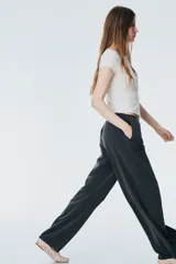 Pantalón gris de corte holgado con elástico y cordón en la cintura, bolsillos laterales y traseros, y piernas rectas. Confeccionado en sarga.