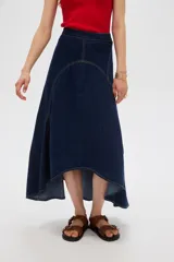 Falda larga de denim azul oscuro con costuras en contraste y diseño asimétrico de corte evasé.