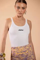 Musculosa blanca estilo tank top, de ajuste ceñido al cuerpo con escote redondo y el texto "Latina" bordado en negro en el centro del pecho.