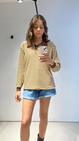 Buzo de punto morley con rayas horizontales color marrón y beige, cuello polo y mangas largas con puños en color marrón liso.