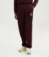 Pantalón deportivo color bordó con rayas blancas laterales, cintura elástica con cordón ajustable, bolsillos laterales y logo pequeño en el muslo.