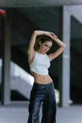 Pantalón de ecocuero negro, corte ancho, con bolsillos laterales y traseros, y cintura elástica en la parte posterior.