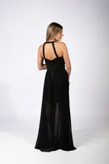 Vestido largo de fiesta con cuerpo superior decorado con apliques geométricos dorados y falda fluida de gasa negra con transparencia.