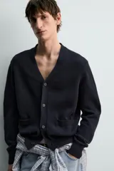 Cárdigan de punto relaxed fit confeccionado en mezcla de algodón y lino, en color azul marino. Presenta cuello en V, manga larga, bolsillos delanteros de plastrón, acabados en rib y cierre frontal con botones.