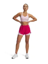 Shorts deportivos de mujer Under Armour con diseño 2 en 1, que combina un pantalón corto exterior ligero en color fucsia con un short de compresión interior en color rosado claro. Cuenta con cintura elástica, paneles de malla para ventilación y bolsillo lateral con cierre.