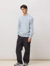 Buzo celeste de cuello redondo, con mangas largas y estampa trasera con la inscripción "blue banana goods".