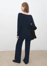 Pantalón azul marino de tiro medio, corte ancho y recto, con pequeñas aberturas en los bajos.
