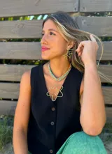 Collar con cadena de eslabones gruesos color naranja y celeste, con dije dorado irregular en forma de flor.