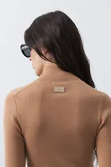 Polera de manga larga y cuello alto, confeccionada en tejido de punto fino, con un ajuste ceñido al cuerpo.