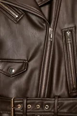 Cazadora biker de efecto piel en color marrón oscuro, con cuello de solapa, cierre frontal cruzado con cremallera, bolsillos laterales con cremallera y cinturón ajustable en el bajo.