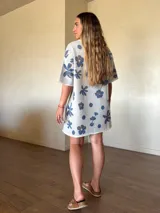 Vestido corto de tejido de punto de algodón con lurex, corte holgado, mangas cortas y cuello redondo, con diseño estampado floral y de lunares en tonos gris y lila sobre base beige claro.