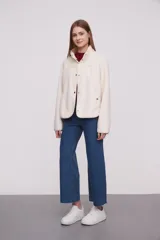 Campera blanca de poliéster con cuello mao, cierre con botones a presión y diseño acolchado en la parte superior.