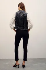 Jean skinny de tiro medio color negro, confeccionado en algodón con elastano, con cierre y botón.