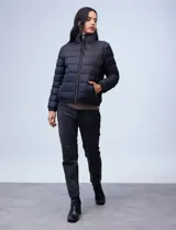 Campera de plumas reversible marca Michael Kors. Un lado es liso y el otro estampado con el logo de la marca. Tiene abertura central con cierre metálico, bolsillos delanteros y avíos metálicos con el logo. Incluye bolsa autoportante.