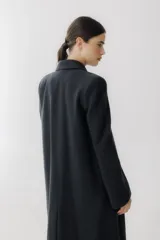 Tapado largo de paño en color beige, con solapas clásicas, cierre frontal de dos botones y corte recto estructurado.