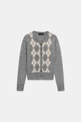 Chaqueta de punto color gris, con cuello pico y manga larga. Presenta un diseño de rombos (argyle) en tonos beige y negro en el frente. Cierre frontal con botones oscuros.