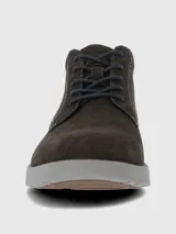 Bota urbana de caña baja confeccionada en cuero gamuzado color marrón oscuro, con cordones al tono y suela de poliuretano gris con tecnología de amortiguación.