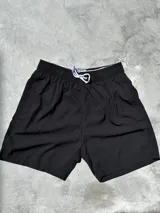 Short de baño negro con cintura elástica y cordón ajustable.