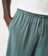 Short de viscosa color verde militar, con cintura elástica, cordón de ajuste y bolsillos laterales y traseros.