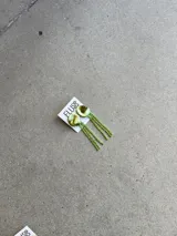 Caravanas colgantes de diseño irregular con base circular texturizada en tono dorado y flecos largos de strass brillantes.