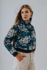 Campera bomber azul petróleo con estampado floral en tonos grises y blancos, cierre frontal y cuello alto.