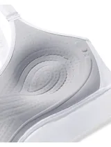 Top deportivo Under Armour modelo Infinity Mid 2.0, color blanco, de sujeción media, con tirantes ajustables y paneles laterales de malla.