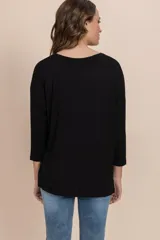 Remera negra de tejido rib con cuello redondo y mangas largas.