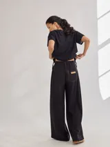Pantalon de tiro medio-alto con pierna ancha, confeccionado en tela de rayón y poliéster. Presenta bolsillos plaque frontales, costuras a contratono y cierre frontal con botón.