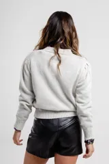 Sweater verde claro de tejido de punto con cuello redondo y mangas largas.