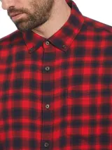 Camisa de franela a cuadros rojos y negros, de manga larga y corte clásico.