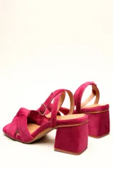 Sandalia de tacón cuadrado medio, confeccionada en terciopelo negro. Presenta un diseño de tiras cruzadas con nudo en la parte delantera y una tira ajustable con hebilla en el tobillo.