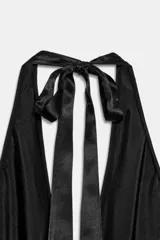 Vestido largo de Zara Woman Collection confeccionado en tejido satinado negro con estampado floral a contraste. Presenta cuello halter ajustable con lazada en la espalda y corte fluido.