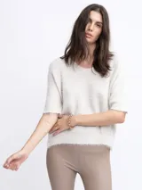 Sweater de punto color beige, de manga corta y corte holgado.