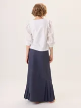 Falda larga color marrón, con diseño de corte asimétrico y tablas en el ruedo que aportan movimiento. Confeccionada en una mezcla de algodón y tencel.