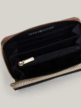 Billetera mediana de Tommy Hilfiger en color azul marino, con cierre de cremallera perimetral. Presenta el monograma TH metálico en dorado en la parte frontal y un tirador de cierre con los colores distintivos de la marca.
