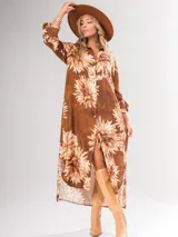 Vestido camisero largo con estampado floral en tonos rojos y negros, con cuello camisero, abotonadura frontal y mangas largas con puños abotonados.