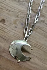 Collar plateado con cadena de eslabones grandes y dije de luna creciente texturizada. El dije está hecho de alpaca y bronce.