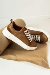 Zapatillas urbanas de cuero, color marrón oscuro, con paneles de gamuza y cuero liso, cordones al tono y suela de plataforma blanca.