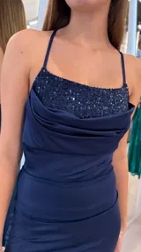 Vestido largo azul marino con tirantes finos, escote drapeado con aplique de lentejuelas en el pecho y tajo lateral en la falda.
