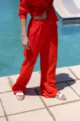 Pantalón de lino color rojo, de corte amplio, con cintura elastizada y lazo ajustable.