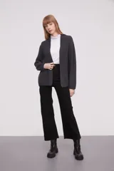 Saco abierto de tejido de punto grueso, color gris, con mangas largas y bolsillos frontales aplicados.