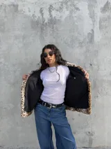 Campera de piel sintética con estampado animal print de leopardo, diseño de corte holgado, cuello solapa y textura suave.