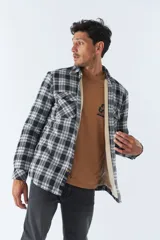 Sobrecamisa de algodón a cuadros color ladrillo, con interior de corderito, cierre con botones, bolsillos tipo cartera y logo en goma. El modelo usa talle M.