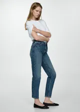 Jeans de corte mom-fit con tiro alto, confeccionados en tejido de algodón estilo vaquero. Presentan diseño de cinco bolsillos, cierre de cremallera con botón y trabillas en la cintura.