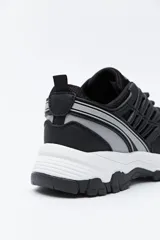 Zapatilla deportiva de estilo trekking con diseño técnico y urbano. Presenta una estructura combinada de paneles de malla y piezas de poliuretano, con sistema de cordones integrado y suela robusta con relieve para mayor estabilidad.