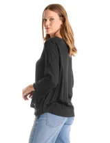 Blusa de rayón color marrón con escote en V, mangas tres cuartos acampanadas y ruedo asimétrico. Presenta detalles de bordado suizo y calados florales en puños y ruedo, con terminación festoneada.