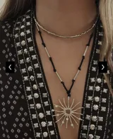 Collar con cadena plateada y dije de sol con incrustaciones de strass.