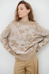 Buzo de tejido de punto con cuello redondo, mangas largas con puños acanalados y diseño estampado de flores en tonos rojos.
