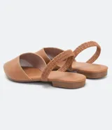 Zapatilla mule color marrón, con puntera fina y tira elástica en el tobillo.